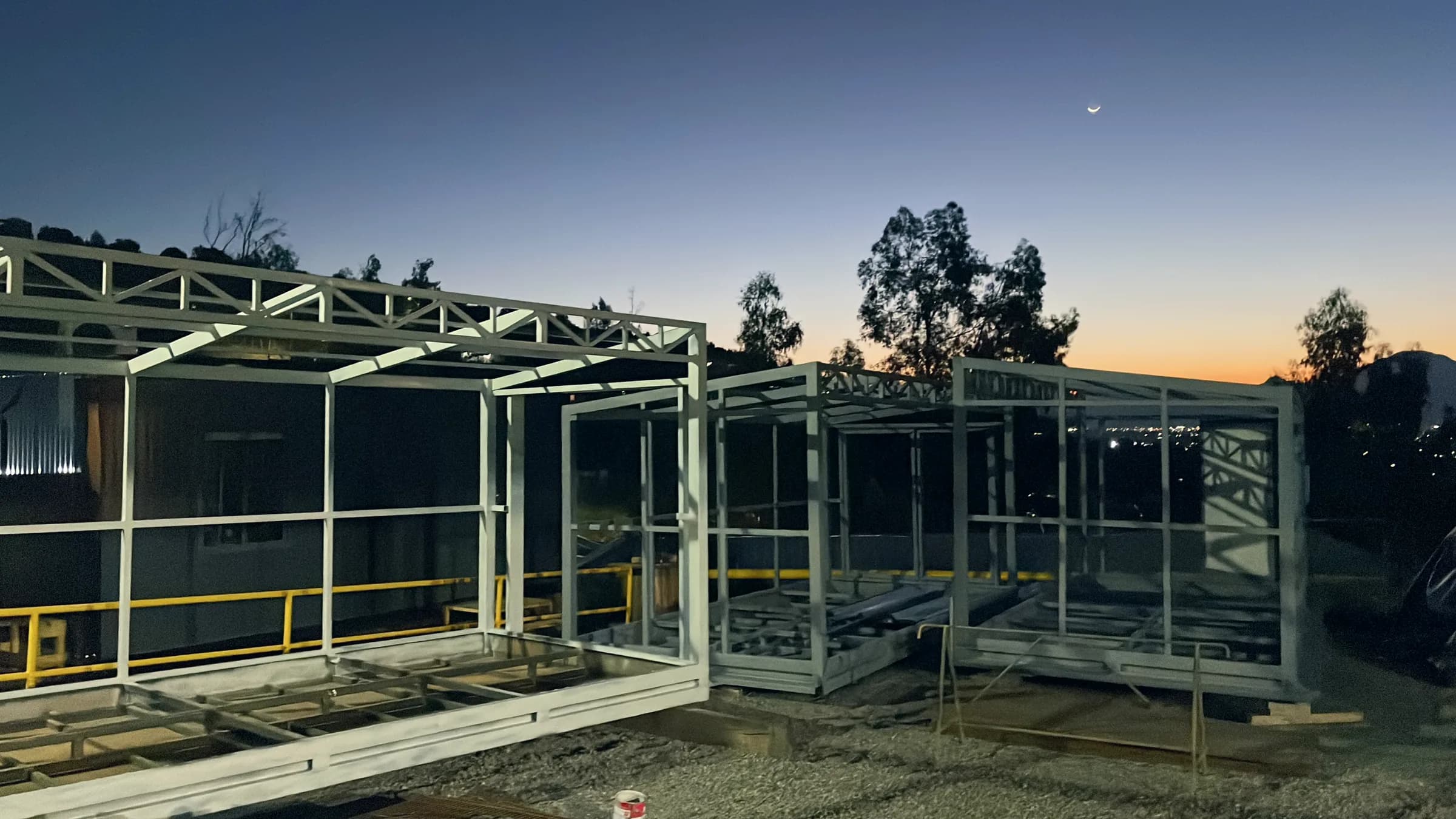 Bodegas modulares de estructura metálica al atardecer, en proceso de montaje